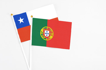 Portugal and Chile stick flags on white background. High quality fabric, miniature national flag. Peaceful global concept.White floor for copy space.