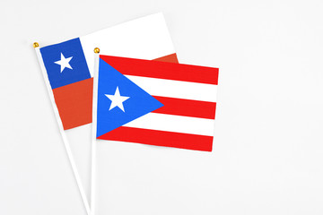 Puerto Rico and Chile stick flags on white background. High quality fabric, miniature national flag. Peaceful global concept.White floor for copy space.
