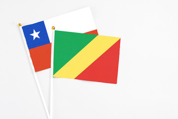 Fototapeta premium Republic Of The Congo and Chile stick flags on white background. High quality fabric, miniature national flag. Peaceful global concept.White floor for copy space.