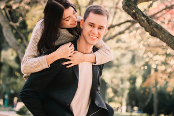 Happy young couple hugging and laughing outdoors.