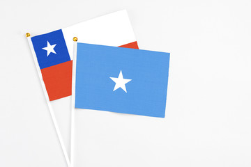 Somalia and Chile stick flags on white background. High quality fabric, miniature national flag. Peaceful global concept.White floor for copy space.