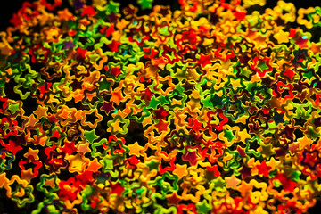 Colored decorative stars on black background. Christmas background