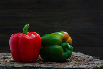 Red and green peppers (Sweet peeper or bell pepper or Capcicum.) Green peppers on wooden with brown background.