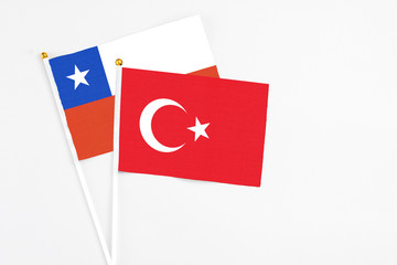 Turkey and Chile stick flags on white background. High quality fabric, miniature national flag. Peaceful global concept.White floor for copy space.