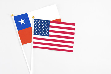 United States and Chile stick flags on white background. High quality fabric, miniature national flag. Peaceful global concept.White floor for copy space.