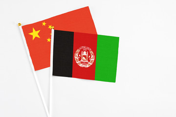 Afghanistan and China stick flags on white background. High quality fabric, miniature national flag. Peaceful global concept.White floor for copy space.