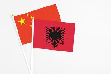 Albania and China stick flags on white background. High quality fabric, miniature national flag. Peaceful global concept.White floor for copy space.