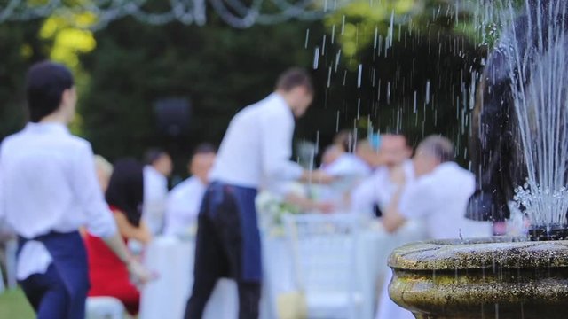 Professional waiters serves a table on the summer terrace of the restaurant, blur view