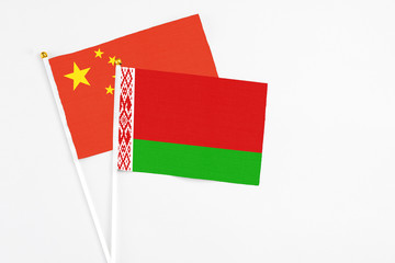 Belarus and China stick flags on white background. High quality fabric, miniature national flag. Peaceful global concept.White floor for copy space.