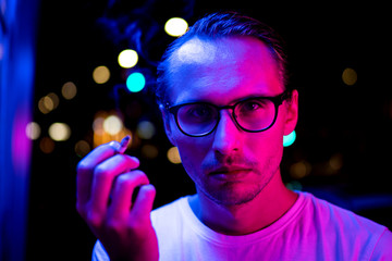 Vintage, red and blue portrait of a young man smoking a cigarette.
