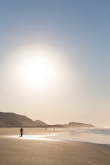 Fototapeta na wymiar Silhouette of cyclist on beach at dawn