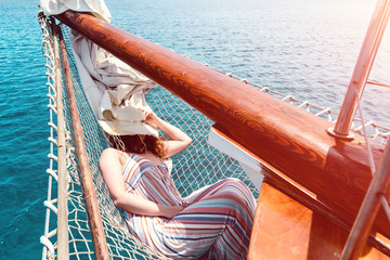 woman in hat resting or sleeping on a ship during sea voyage