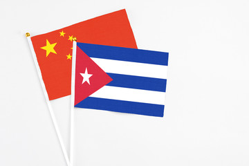 Cuba and China stick flags on white background. High quality fabric, miniature national flag. Peaceful global concept.White floor for copy space.