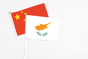 Cyprus and China stick flags on white background. High quality fabric, miniature national flag. Peaceful global concept.White floor for copy space.
