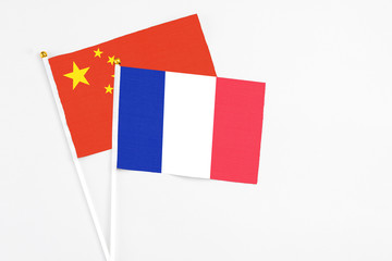 France and China stick flags on white background. High quality fabric, miniature national flag. Peaceful global concept.White floor for copy space.