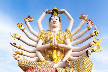 Closeup statue of guanyin buddhism goddess with 18 hands at wat plai laem samui thailand with blue...
