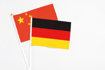 Germany and China stick flags on white background. High quality fabric, miniature national flag. Peaceful global concept.White floor for copy space.