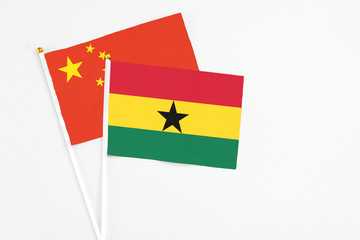 Ghana and China stick flags on white background. High quality fabric, miniature national flag. Peaceful global concept.White floor for copy space.