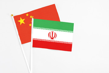 Iran and China stick flags on white background. High quality fabric, miniature national flag. Peaceful global concept.White floor for copy space.