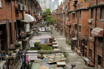 Old street in Shanghai, China. washed clothes drying outdoor .Modern buildings in background