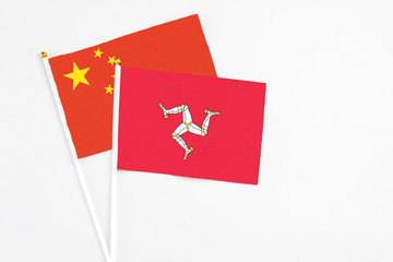 Isle Of Man and China stick flags on white background. High quality fabric, miniature national flag. Peaceful global concept.White floor for copy space.
