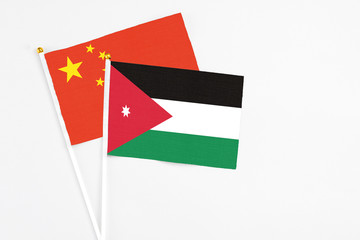 Jordan and China stick flags on white background. High quality fabric, miniature national flag. Peaceful global concept.White floor for copy space.