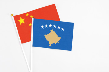 Kosovo and China stick flags on white background. High quality fabric, miniature national flag. Peaceful global concept.White floor for copy space.