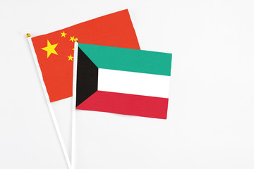 Kuwait and China stick flags on white background. High quality fabric, miniature national flag. Peaceful global concept.White floor for copy space.