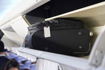 view of carry on luggage on overhead shelf in the airplane cabin