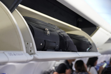 view of carry on luggage on overhead shelf in the airplane cabin