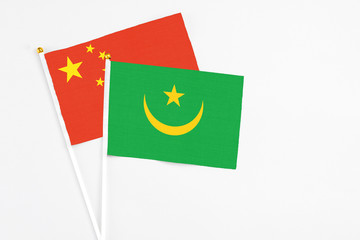 Mauritania and China stick flags on white background. High quality fabric, miniature national flag. Peaceful global concept.White floor for copy space.