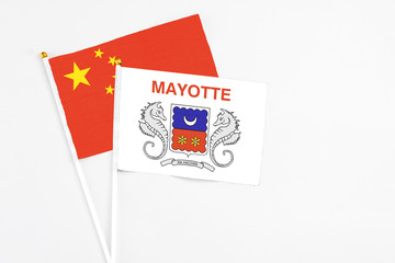 Mayotte and China stick flags on white background. High quality fabric, miniature national flag. Peaceful global concept.White floor for copy space.