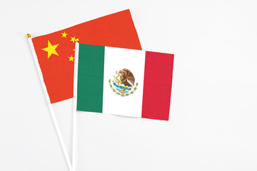 Mexico and China stick flags on white background. High quality fabric, miniature national flag. Peaceful global concept.White floor for copy space.
