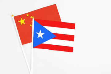 Puerto Rico and China stick flags on white background. High quality fabric, miniature national flag. Peaceful global concept.White floor for copy space.