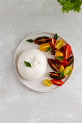 Salad with italian burrata cheese, fresh ripe tomatoes and basil