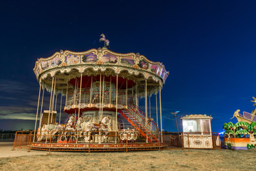Vintage carousel with horses at night. Carousel against the night sky