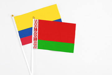 Belarus and Colombia stick flags on white background. High quality fabric, miniature national flag. Peaceful global concept.White floor for copy space.