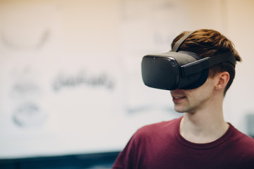 Young man in virtual reality goggles, vr glasses headset with joystick