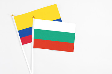 Bulgaria and Colombia stick flags on white background. High quality fabric, miniature national flag. Peaceful global concept.White floor for copy space.