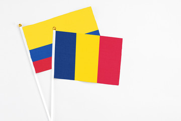 Chad and Colombia stick flags on white background. High quality fabric, miniature national flag. Peaceful global concept.White floor for copy space.