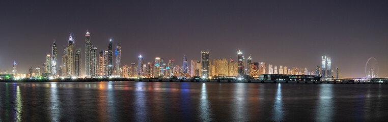 Fototapeta na wymiar Dubai skyline panorama at night showing skyscrapers and new constructions and lights on the water