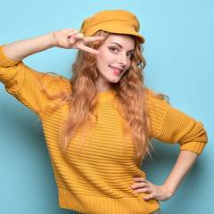 Fashionable woman smiling having fun in stylish yellow outfit, makeup. Happy beautiful redhead girl in trendy jumper, yellow cap, fashion hair. Cheerful young model, funny mood colorful concept