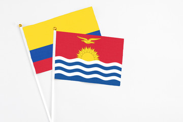 Kiribati and Colombia stick flags on white background. High quality fabric, miniature national flag. Peaceful global concept.White floor for copy space.