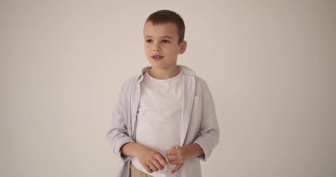 Thoughtful boy counting on his fingers over white background