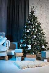 Winter home decor. Christmas tree in loft interior against brick wall.