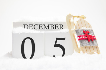 Wooden calendar for December, 5 th day of the winter month. The symbols of winter are snow and...