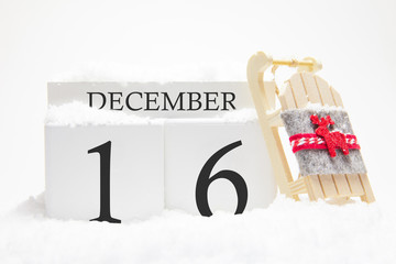 Wooden calendar for December, 16 th day of the winter month. The symbols of winter are snow and...