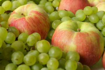 Fresh green grapes bunches and apples. Vegan food.