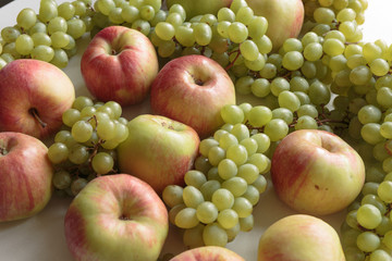 Fresh green grapes bunches and apples. Vegan food.