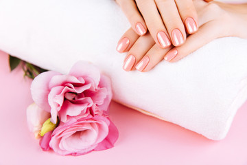 Obraz na płótnie Canvas Beautiful Woman Hands . Spa and Manicure concept. Female hands with pink manicure. Soft skin skincare concept. Beauty nails. Over beige background